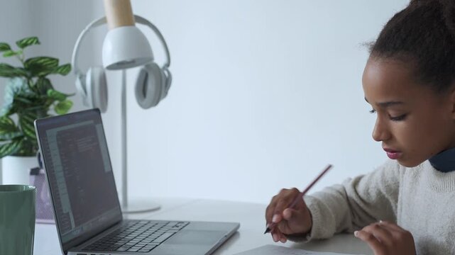 Primary middle school African American Student child girl study use laptop. Distance learning online education. School girl type at home with digital tablet computer and doing school homework. - Powered by Adobe