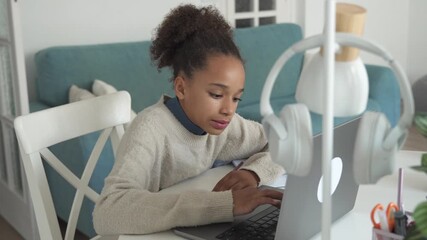 Primary middle school African American Student child girl study use laptop. Distance learning online education. School girl type at home with digital tablet computer and doing school homework. - Powered by Adobe