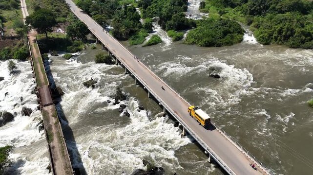 Aerial drone video of a bridge spanning the Binga Falls in Angola, capturing the dramatic view of rushing water and wild landscape below from above