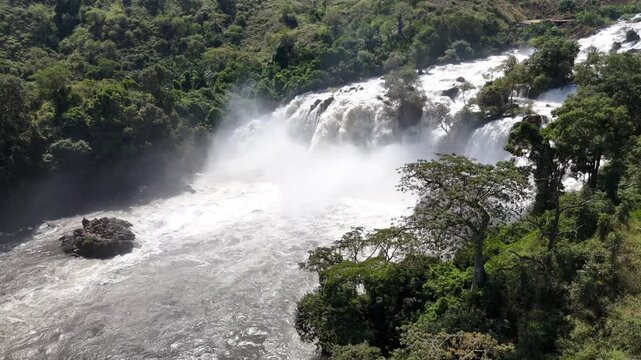 Side aerial view of Binga Falls, Angola, showing powerful torrents of water and mist rising among lush tropical forest in one of Africa&rsquo;s wild natural wonders