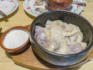 Bowl of dumplings sits on a wooden tray