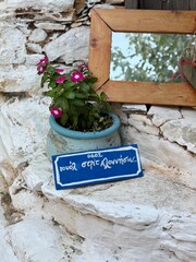 Scenic street in Alonnisos island, Greece, with traditional stone pathways, whitewashed houses, colorful wooden doors, and blooming bougainvillea. Peaceful Mediterranean atmosphere, narrow alleys with