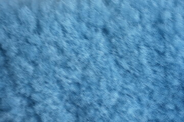 blue natural sheepskin fleece showing its soft, curly wool fibers. The detailed texture highlights the fluffy, warm, and organic structure of genuine sheep wool, often used for clothing, rugs, and coz