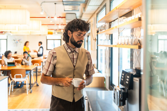 Man preparing coffee in modern coworking office