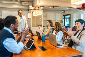 Business colleagues applauding successful presentation in a modern office