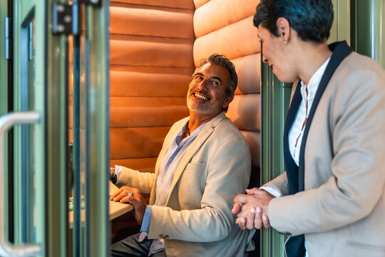 Colleagues collaborating in a modern office meeting pod - Powered by Adobe