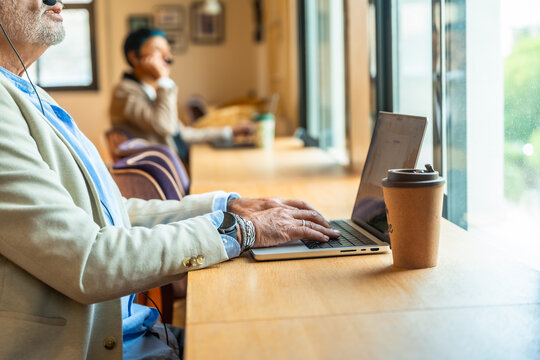 Senior professional working on laptop in modern coworking space