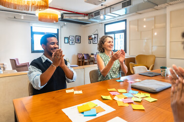Diverse colleagues applauding successful brainstorming session in coworking office