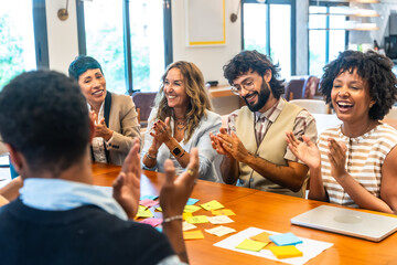 Diverse business team applauding success during office meeting