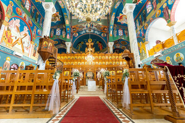 Obraz premium Beautiful interior of a vibrant church during a ceremony with colorful decorations and wooden benches