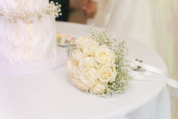 Beautiful white rose bouquet resting on a table during a wedding reception celebration