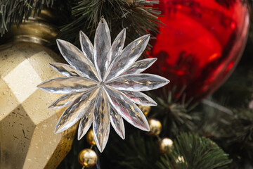 Christmas tree with white snowflake and lights garland. Xmas card. Close up. Winter. Outdoors.