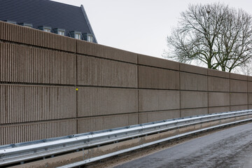 Sound barrier constructed of fibers and concrete along new highway enhances noise control in the...