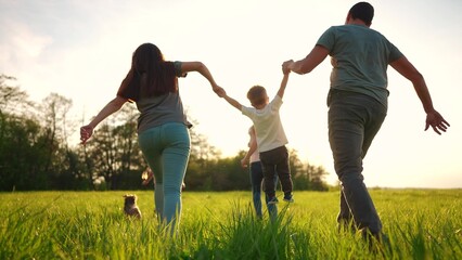 happy family running in the park in summer. mom and dad hold their son by the hands run throw up in the forest park on the grass in the summer. happy family kid dream concept lifestyle © ibragimova