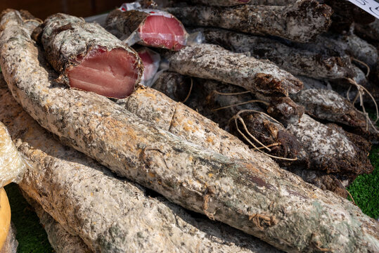 Close-up of Italian salami and lonza displayed at a street market, traditional cured meats.