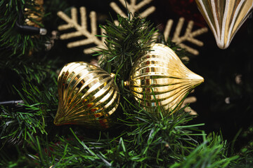 Christmas tree with golden balls and baubles and lights garland. Xmas card. Close up. Winter. Outdoors.