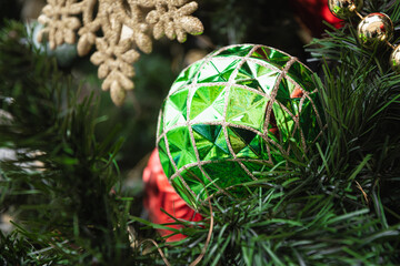 Christmas tree with green ball and shiny lights garland. Xmas greeting card. Close up. Winter. Outdoors.