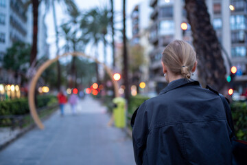 Woman walking on urban street at dusk