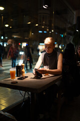 Woman in cafe using smartphone at night