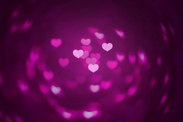 Abstract beautiful blurred brightness pink colored of heart bokeh with swirling background from ornamental lights flickering in the park. The image for Valentine day or Love concept.