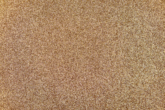 Shimmering gold glitter texture background with sparkling particles, creating a festive and luxurious decorative surface for holiday or celebration designs