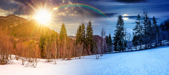 snow covered slope with forest on spring equinox. day and night time change concept. stunning...