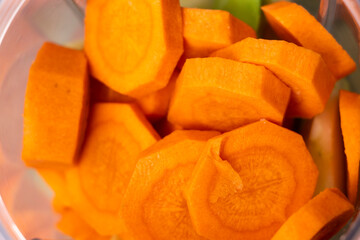 Close-up of fresh, vibrant orange carrot slices arranged neatly in a bowl. Perfect for healthy recipes, preparing meals, or promoting nutrition in food photography.