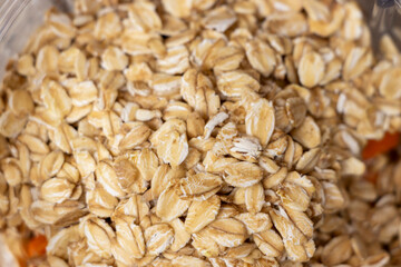 Close-up of oatmeal grains displayed in a transparent container. Perfect for healthy eating, cooking or breakfast ideas. Ideal for nutrition-focused content.
