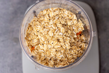 A close-up view of uncooked oats in a blending jar, highlighting the grains natural texture and color. Ideal for health and wellness content or food photography.