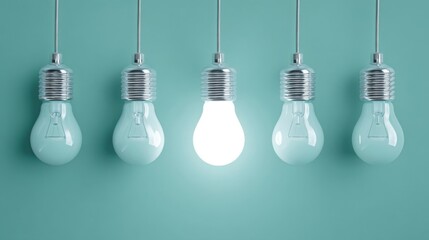 Five hanging light bulbs against a teal background, four bulbs off with clear glass and filaments,