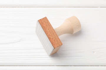 One wooden stamp on white table, top view