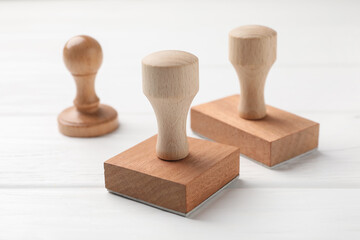 Three wooden stamps on white table, closeup