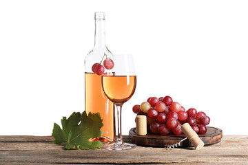 Rose wine in glass, bottle, grapes, corkscrew and leaf on wooden table against white background