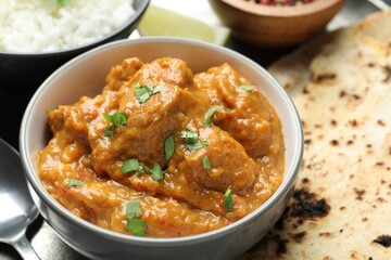 Delicious chicken tikka masala, cilantro and lavash on plate, closeup
