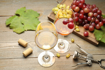 Tasty rose and white wine, grapes, corkscrew on wooden table, closeup