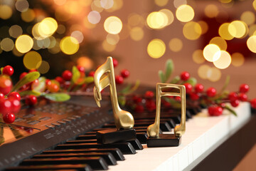 Golden music notes and Christmas decor on piano indoors, closeup
