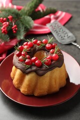 Tasty cake with cranberries and Christmas decor on grey table, closeup
