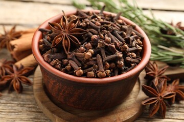 Mulled wine spices. Cloves and anise star in bowl on wooden table, closeup