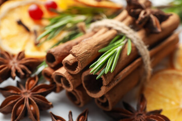 Mulled wine spices. Cinnamon sticks, fresh rosemary, anise stars and dry orange slices on table,...