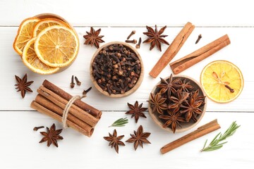 Different spices, dry orange slices and fresh rosemary for mulled wine on white wooden table, flat lay