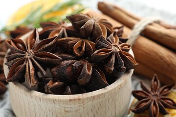 Mulled wine spices. Anise stars in bowl and cinnamon sticks on table, closeup