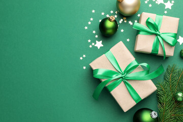 Beautiful Christmas composition with gifts and decor on green background, flat lay. Space for text