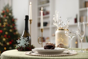 Festive table setting with Christmas decor and burning candles indoors, closeup