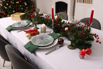 Festive table setting with Christmas decor and burning candles indoors, closeup