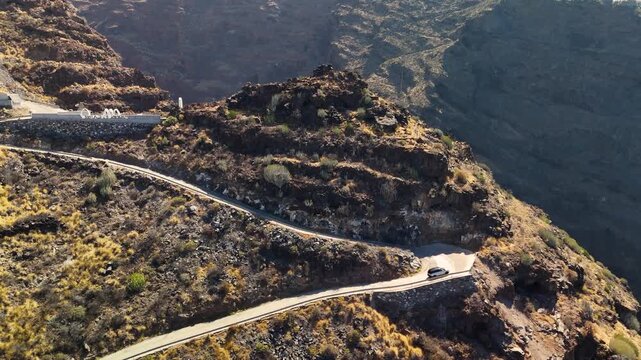 Aerial drone shot panning out revealing the dramatic winding road and volcanic cliffs leading to Por&iacute;s de Candelaria, La Palma, Canary Islands, Spain.
