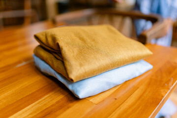 Warm golden and pastel blue folded fabrics create a calming, cozy, and inviting atmosphere for home decor, textile design, or sustainable fashion projects