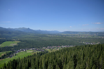 High Tatras and Male Ciche ski resort seen from a metal observation tower with a modern glass terrace offering a stunning panorama at Poronin, Poland. Majestic mountains peaks of High Tatra moutnains.