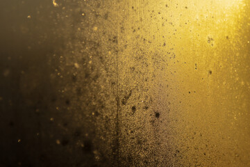 Abstract golden texture with shimmering particles and soft light reflections in the background