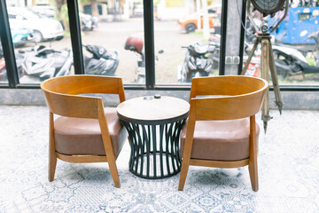 Inviting cafe corner with wooden chairs and bistro table perfect for intimate conversations or quiet moments in a vibrant urban setting with motorcycles outside