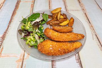 Breaded chicken fillets coated in a mixture of breadcrumbs and Parmesan cheese, browned evenly in olive oil and served with spaghetti pomodoro and fresh basil